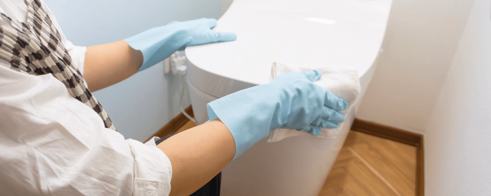 トイレ清掃の作業イメージ（便器まわりを拭き掃除している様子）